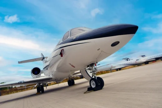 Charter-a ltd luxury private jet on tarmac under a blue sky.